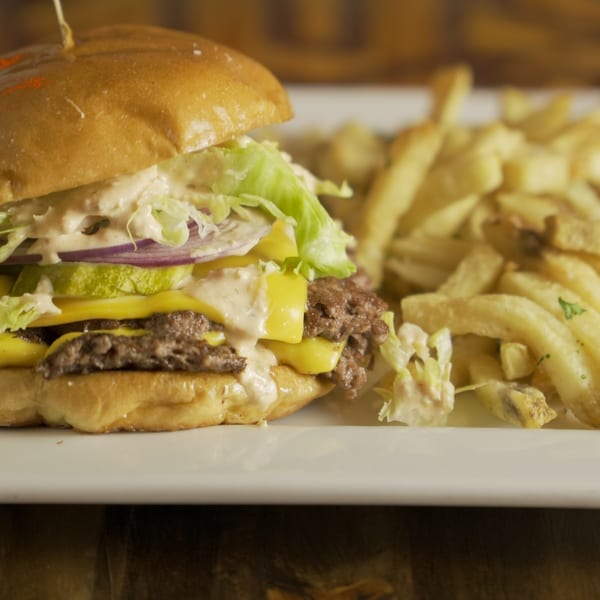 Double cheeseburger with lettuce, onion, pickles, and special sauce, served with french fries.